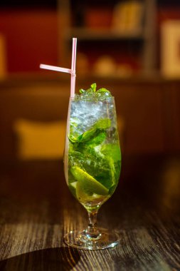 Bardakta parlak içkiler, arka planda ışık ve duman. Farklı renkte kokteyller