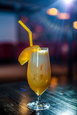 Bardakta parlak içkiler, arka planda ışık ve duman. Farklı renkte kokteyller