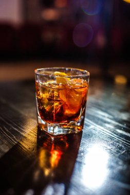 Bardakta parlak içkiler, arka planda ışık ve duman. Farklı renkte kokteyller