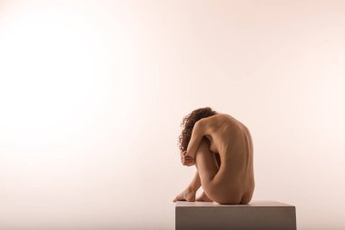 Stüdyoda beyaz tenli güzel bir kız var. Beyaz arka planda, ince estetik bir vücutta.