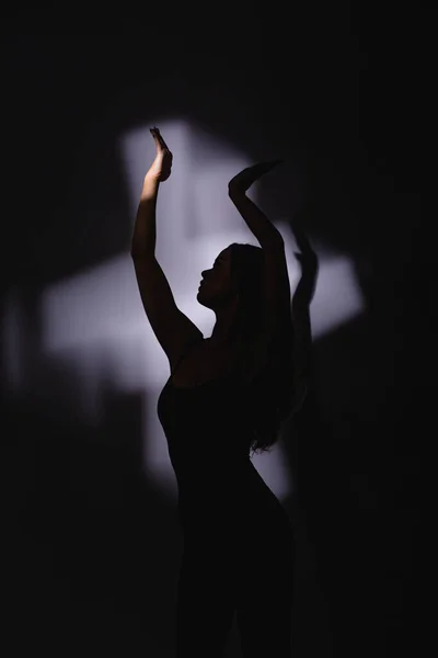 Girl dancer, flexible plastic, dancing in a jump. spotlight, hand shadow.