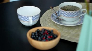 Bir insanın sıcak çayı kaşıkla karıştırmasının en üst görüntüsü. Çay ve berbat içki konsepti. Çay fincanını ahşap masaya kapat..