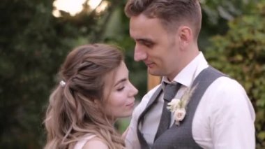 Beyaz gelin ve damat açık havada romantik bir dans eder ve yakın plan sohbet ederler.