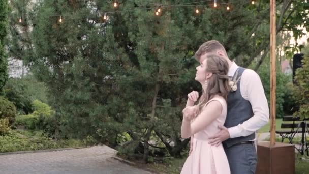新娘和新郎在绿树成荫的背景下 缓缓地跳着浪漫舞曲 在空旷的天空中互相微笑 旋转着 — 图库视频影像