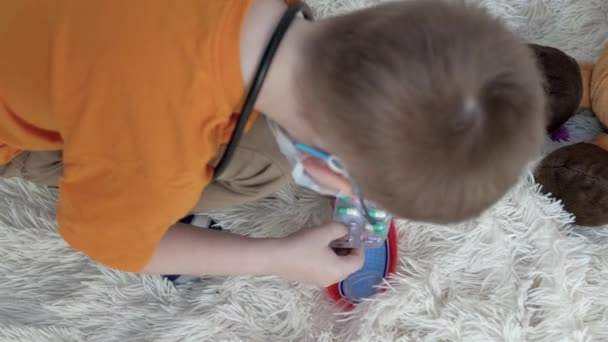 Ein Junge Mit Orangefarbener Maske Brille Auf Dem Boden Auf — Stockvideo