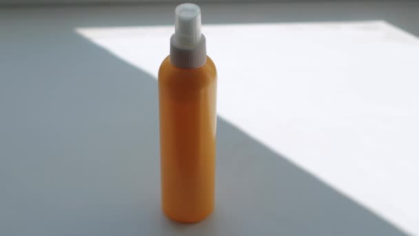 在一个白色的表面上 在一个公寓里 在一个房间里 在阳光下 有一个橙色的瓶子 一个男人的手拿着它的特写 一个静态特写镜头 — 图库视频影像