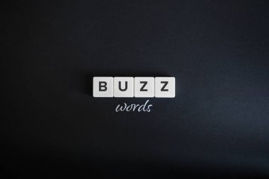 Buzzwords konsepti. Blok harfler ve siyah arkaplanda el yazısı. Asgari estetik.