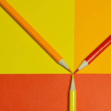 Renkli arka planda sarı, turuncu ve kırmızı kalem. Sıcak renk paleti.