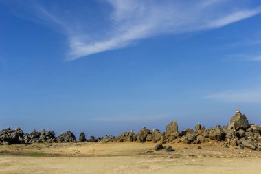 Aruba 'nın engebeli doğu kıyısındaki Cairn Meydanı Doğal Köprü' ye yakın..