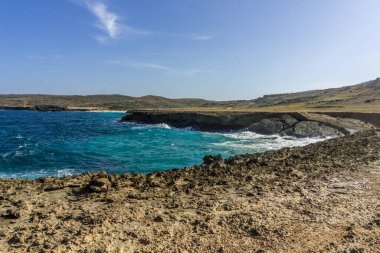 Derin mavi sular ve Aruba 'nın engebeli doğu kıyıları Doğal Köprü' ye yakın..