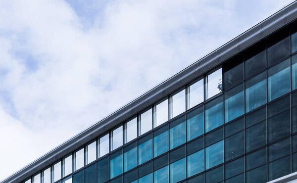 Detail of a modern building with glass sandwich facade panels. Abstract architecture photography.