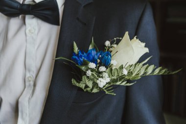 Damat yaka çiçeğini düğün gününden önce şık bir gelin giyer. Beyaz gömlekli mavi bir gelinlik ve şık bir fiyonk..