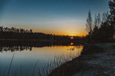 Gün batımını tarlada güneşin batışını yansıtan gölün üzerinde.