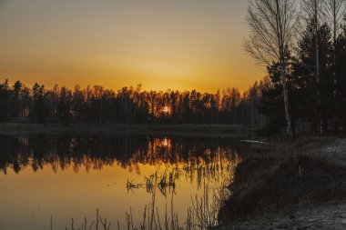 Gün batımını tarlada güneşin batışını yansıtan gölün üzerinde.