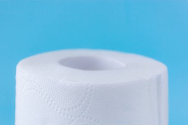 Mavi arka plandaki beyaz tuvalet kağıdı rulosunun üst kısmını kapat. metin için boşluk kopyala. Hijyen kavramı 