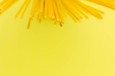 Sarı arka planda uzun sarı makarna. Sarı İtalyan makarnası. İtalyan yemeği ve mutfak konsepti. Boşluğu kopyala 