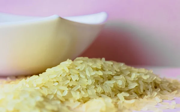 Primo piano di riso bianco con tazza bianca su sfondo rosa . — Foto Stock