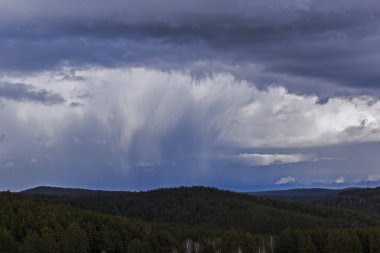 Mavi gökyüzüne yağan yağmurlu arka planda dramatik fırtına bulutları. süslü yaz konsepti