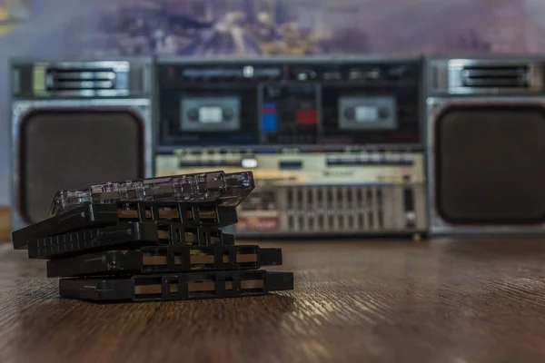 Arka planda retro teyp ile ahşap yüzeyde duran eski kaset kasetleri. retro 90 'ların müzik konsepti