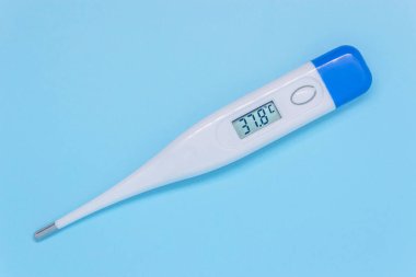 Mavi arka planda beyaz dijital elektronik termometre yüksek ateşi gösteriyor. Tıbbi muayene kavramı