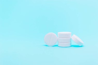 Beyaz, mavi arka planda fotokopi alanı olan yuvarlak haplar. Tıbbi tedavi veya eczane fotokopi alanı kavramı 