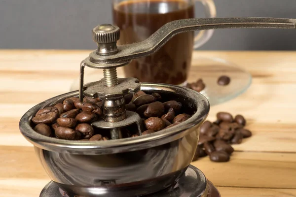 Coffee mill, coffee beans and a cup