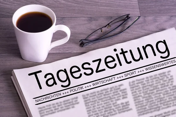 Uma chávena de café e um jornal alemão — Fotografia de Stock