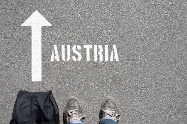 Arkaplan için asfalt üzerinde duran kişinin bulunduğu yazıt Avusturalya ve ok