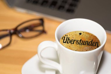 Bilgisayar, kahve bardağı ve fazla mesai.