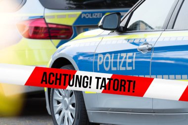 Olay yerinde bir polis arabası ve polis bandı var.