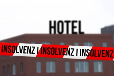İflas uyarısı olan bir otel ve bariyer bandı.