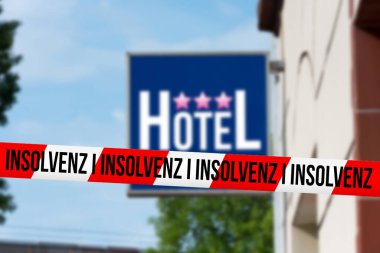 İflas uyarısı olan bir otel ve bariyer bandı.