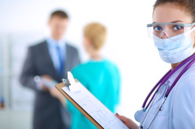 Kadın doktor hastanede dosyayla bekliyor.