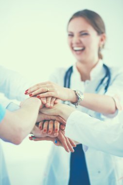 Doktorlar ve hemşireler tıbbi bir ekipte el ele tutuşuyorlar.