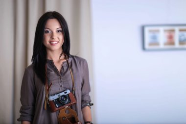 Masada dizüstü bilgisayarla oturan kadın fotoğrafçı.