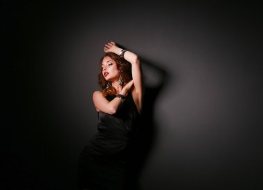 Siyah elbiseli, akşam makyajlı güzel bir kadın.