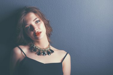 Siyah elbiseli, akşam makyajlı güzel bir kadın.