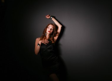 Siyah elbiseli, akşam makyajlı güzel bir kadın.