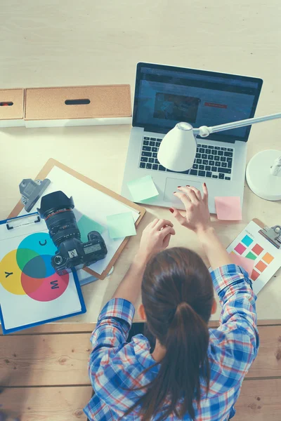 Female photographer sitting on the desk with laptop — Stock Photo, Image