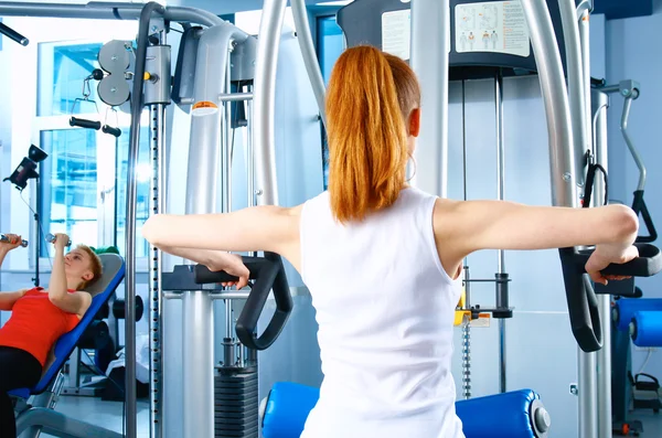 Vacker flicka på gymmet tränar på utbildare — Stockfoto