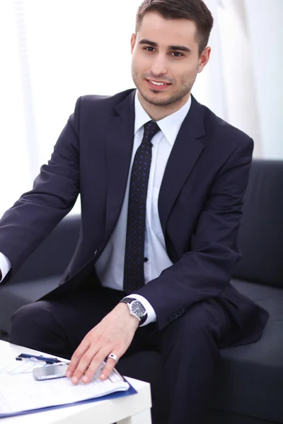 Young businessman working in office, sitting at desk — Stock Photo, Image