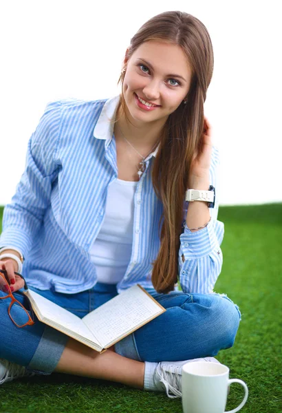 Jonge vrouw zitten met boek op gras — Stockfoto