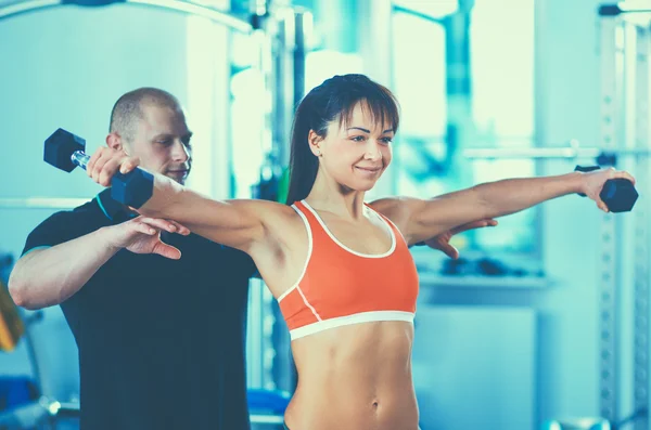 Schöne Frau im Fitnessstudio beim Training mit ihrem Trainer — Stockfoto