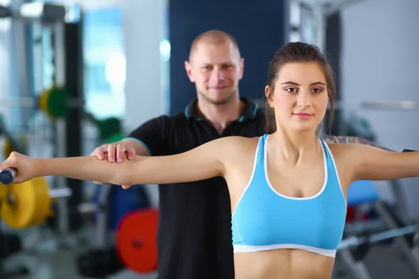 Vacker kvinna på gymmet tränar med hennes tränare — Stockfoto
