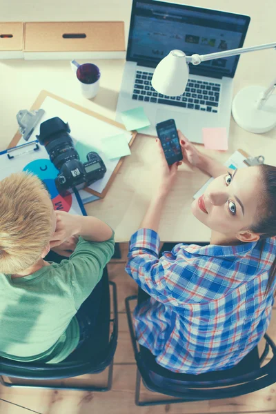 Female photographer sitting on the desk with laptop — Stock Photo, Image