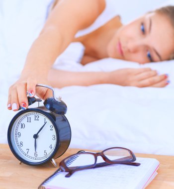 Genç bir kadın sabah alarmını erteliyor.