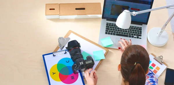 Female photographer sitting on the desk with laptop — Stock Photo, Image