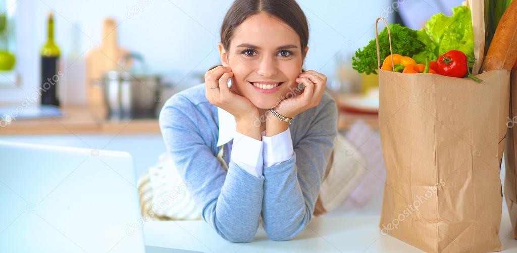 Portrait of a smiling woman cooking in her kitchen sitting