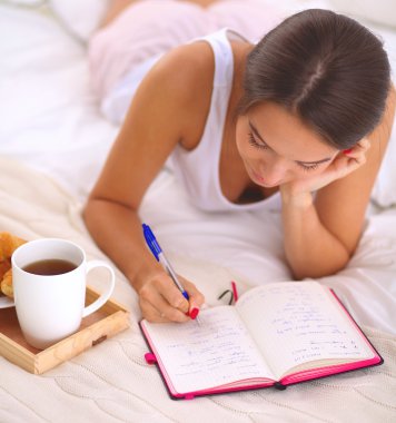 Bir günlük yazma yatakta yatan genç güzel kadın