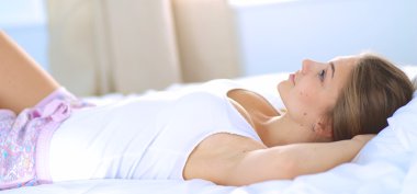 Yatakta rahat ve mutlu bir şekilde yatan güzel bir genç kadın.